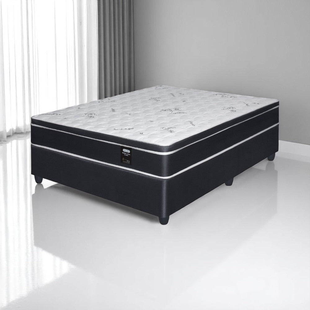 Black and white mattress set on a white floor with gray walls
