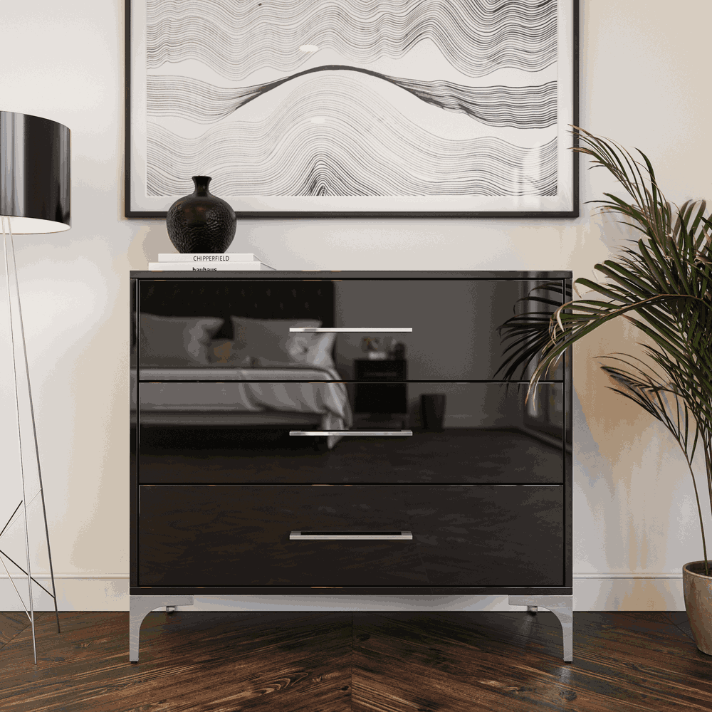 Black dresser with a plant and lamp in a modern room.