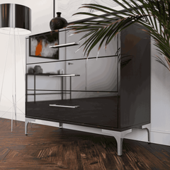Modern black dresser with silver legs in a room setting.