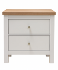 White nightstand with two drawers and a wooden top on a white background