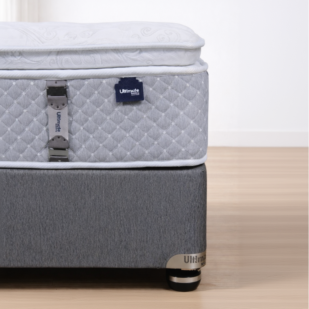 Gray mattress with quilted top and branded label on a wooden floor.