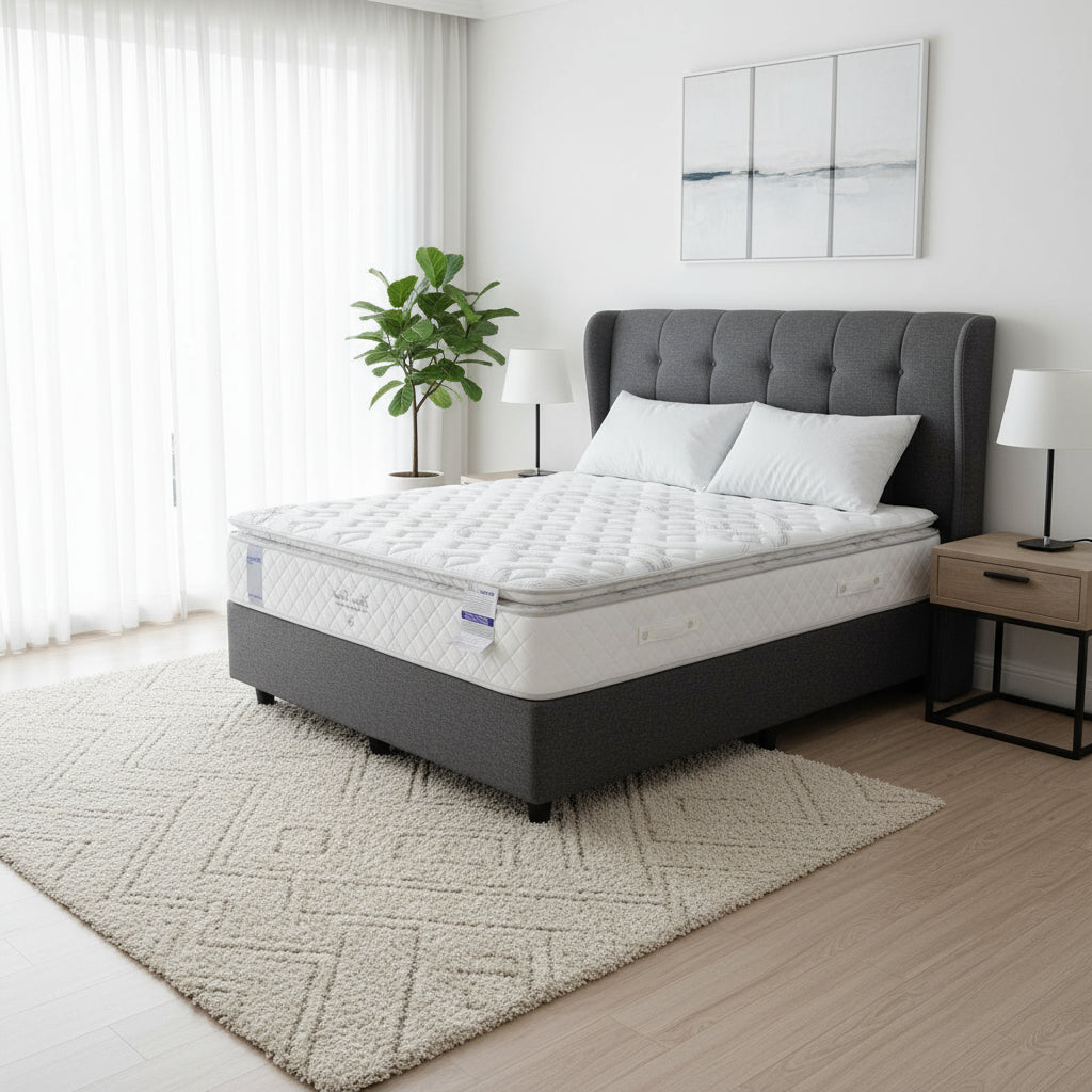 Mattress on a bed frame in a room with a rug and shelves.