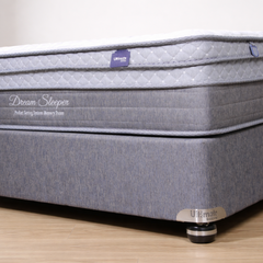 Gray mattress with 'Dream Sleeper' branding on a wooden floor.