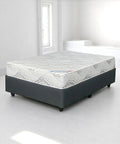 Mattress on a bed frame in a minimalistic room with white walls and floor.