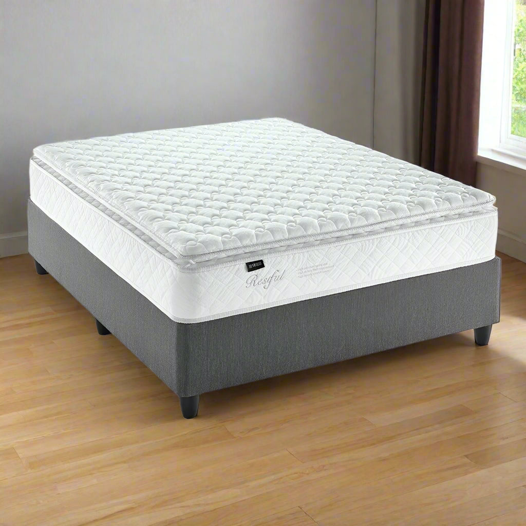 A Henwood brand pillowtop queen bed set with a white mattress on a gray base.