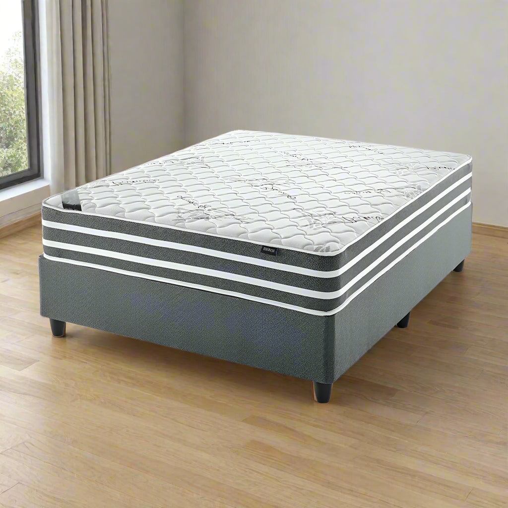 Gray mattress with white quilted surface on a white background