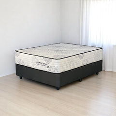 Mattress on a wooden floor with a white wall background