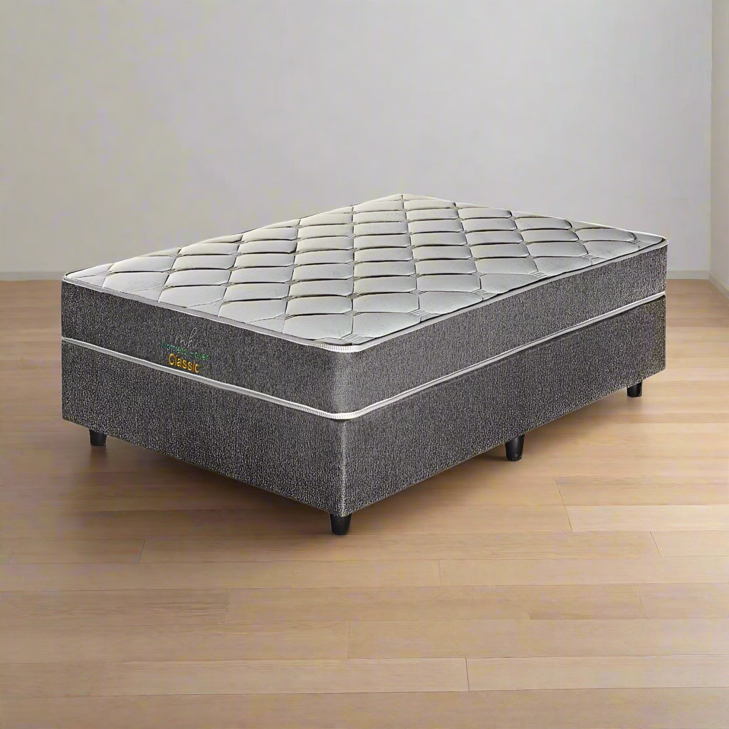 A traditional bonnell spring queen-sized mattress set on a frame, with a quilted design on the top surface.