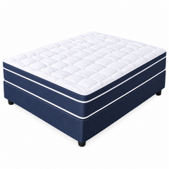 A mattress on a navy blue upholstered bed base, photographed on a clean white background. The mattress has a quilted white top and the base is navy with thin white piping accents.