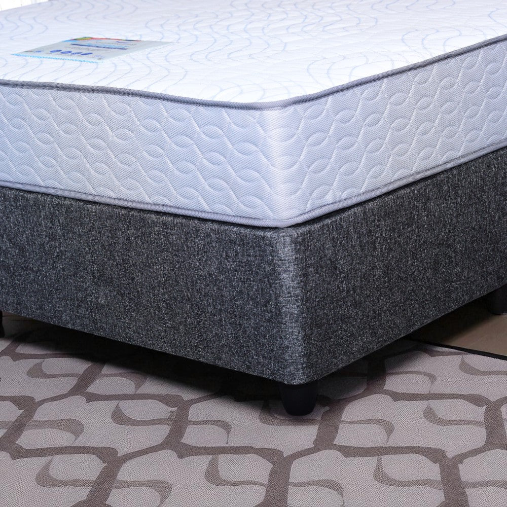 Gray and white mattress on a patterned floor