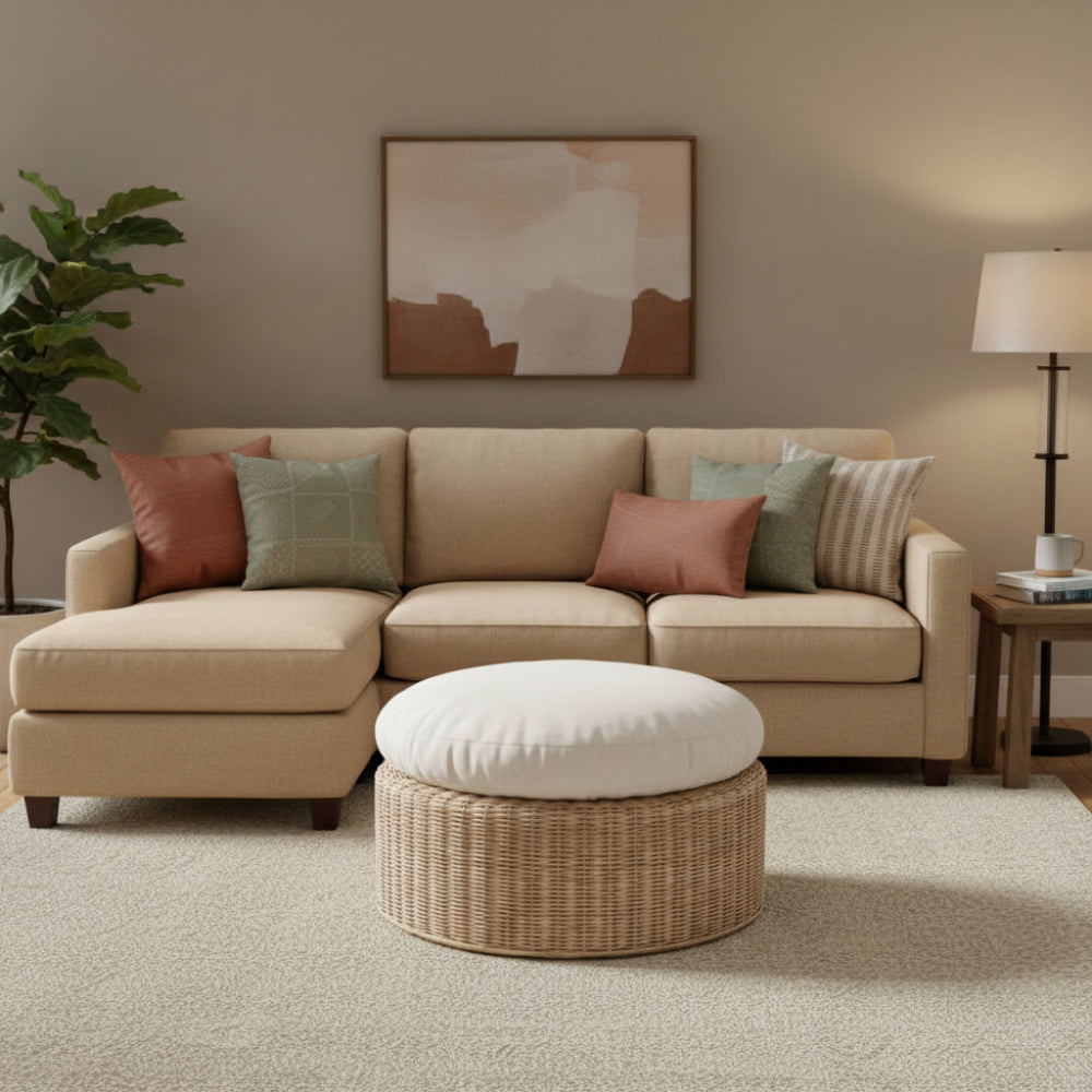 Wicker ottoman with a white cushion on a white background