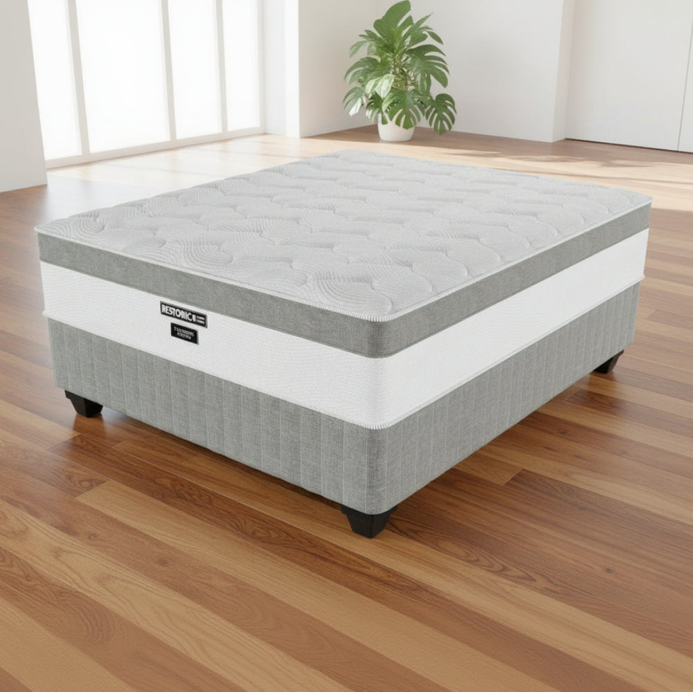 Gray and white mattress with 'RESTON' branding on a white background